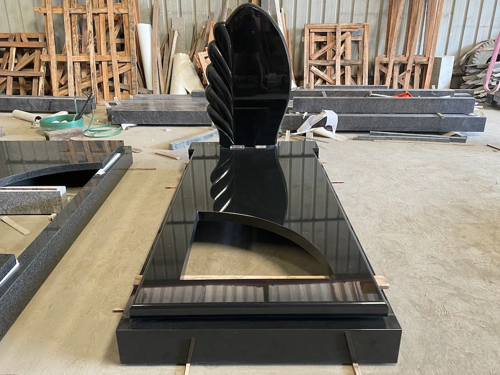 Indian Black granite German-style tombstone with wing-shaped headstone and polished wave cover slabs